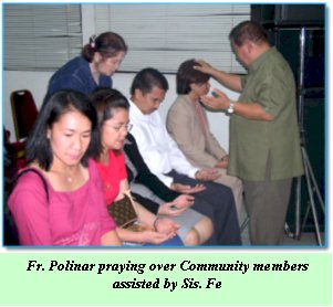 Fr. Polinar praying over Community members assisted by Sis. Fe